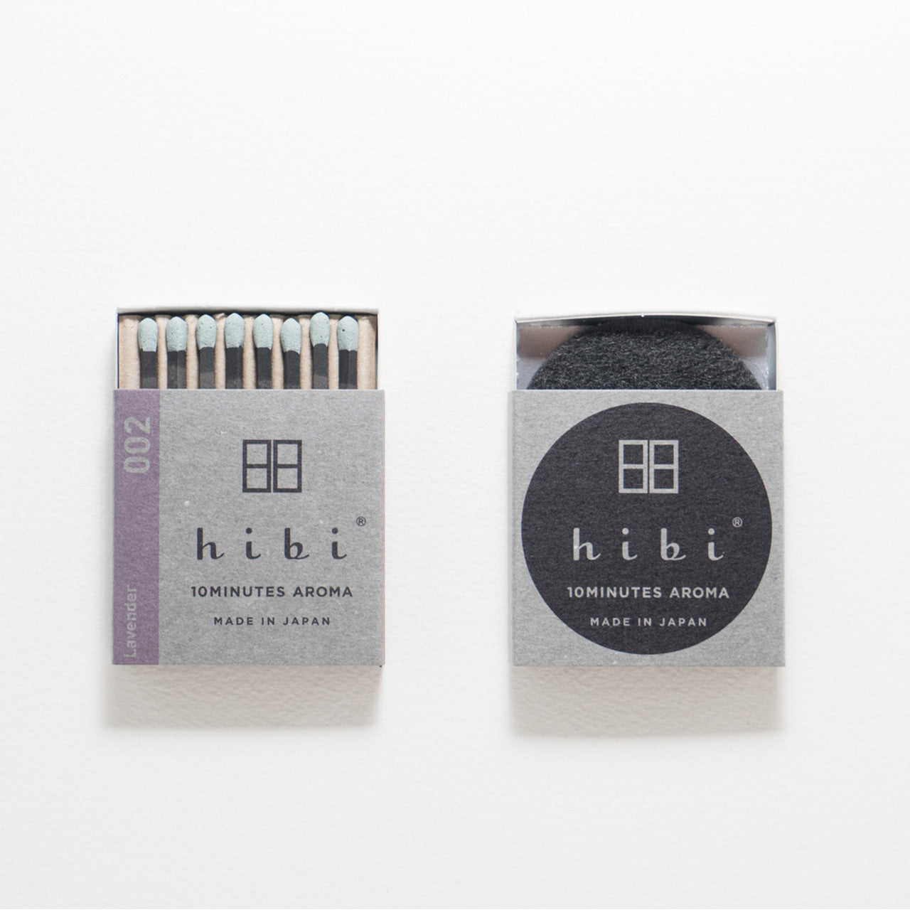 An opened box of Hibi 10 Minutes Aroma Lavender incense matches containing 8 incense sticks with light blue tips. Next to it is a box containing a non-flammable incense mat. All set in a white background.