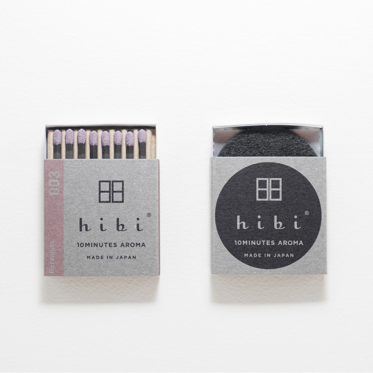 An opened box of Hibi 10 Minutes Aroma Geranium matches containing 8 incense sticks with light purple tips. Next to it is a box containing a non-flammable incense mat All set in a white background.