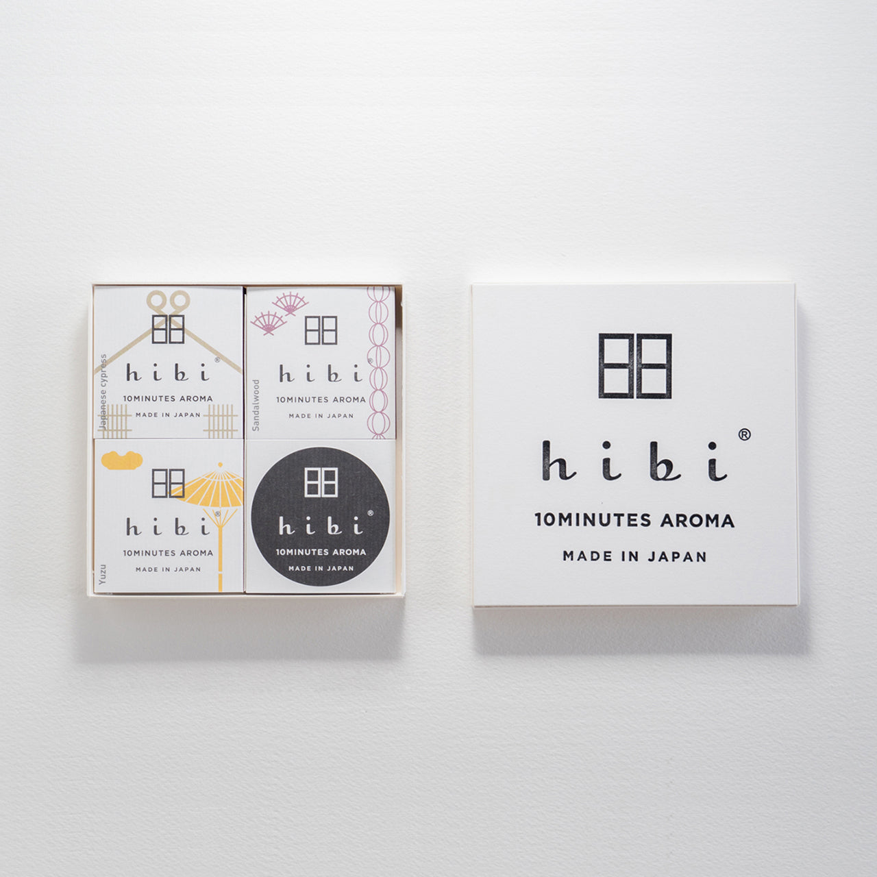 An opened white Hibi 10 Minutes Aroma gift box containing three packs of Japanese Cypress, Sandalwood, and Yuzu incense matches and a non-flammable incense mat, against a white background.