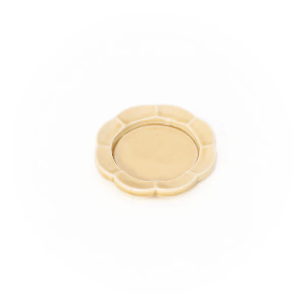 A yelllow flower-shape porcelain Seto incense tray with a white background.
