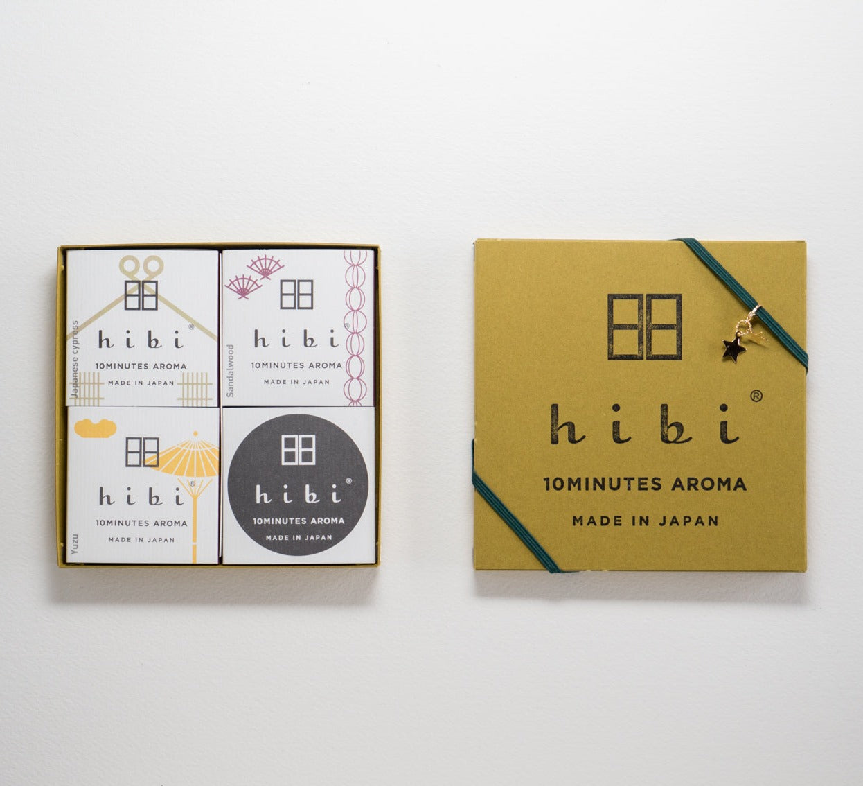An opened yellow gift box of Hibi 10 Minutes Aroma containing three packs of Japanese Cypress, Sandalwood, and Yuzu incense matches and a non-flammable incense mat, against a white background.