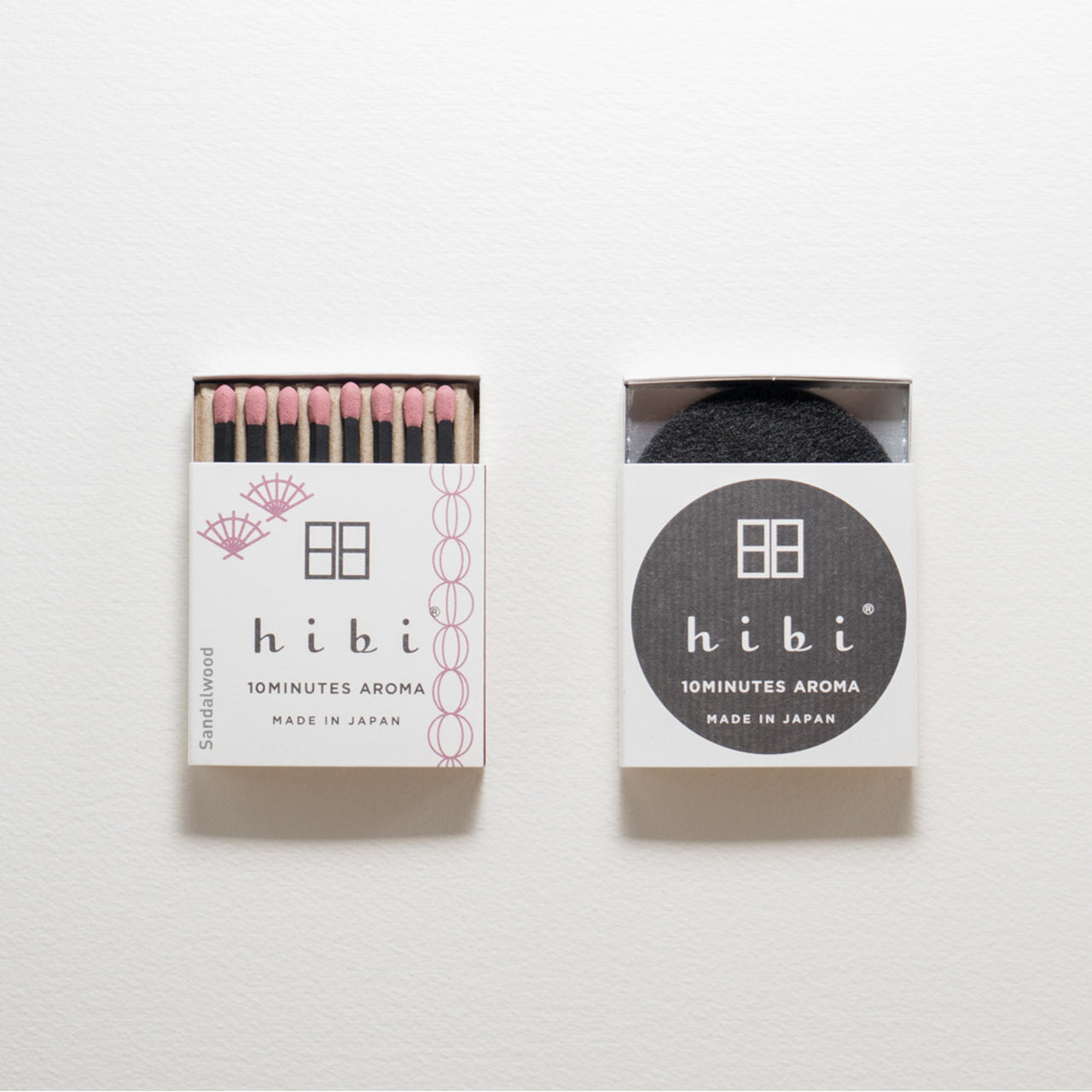 An opened box of Hibi 10 Minutes Aroma Sandalwood incense matches which contains 8 incense sticks with pink tips. Sitting next to it is a box containing a non-flammable mat. All set in a white background.
