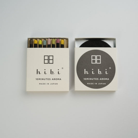 An half opened box of Hibi 10 Minutes Aroma Special Edition showing 8 coloured incense match. Next to it is a box containing a non-flammable incense mat. All set in a white background.